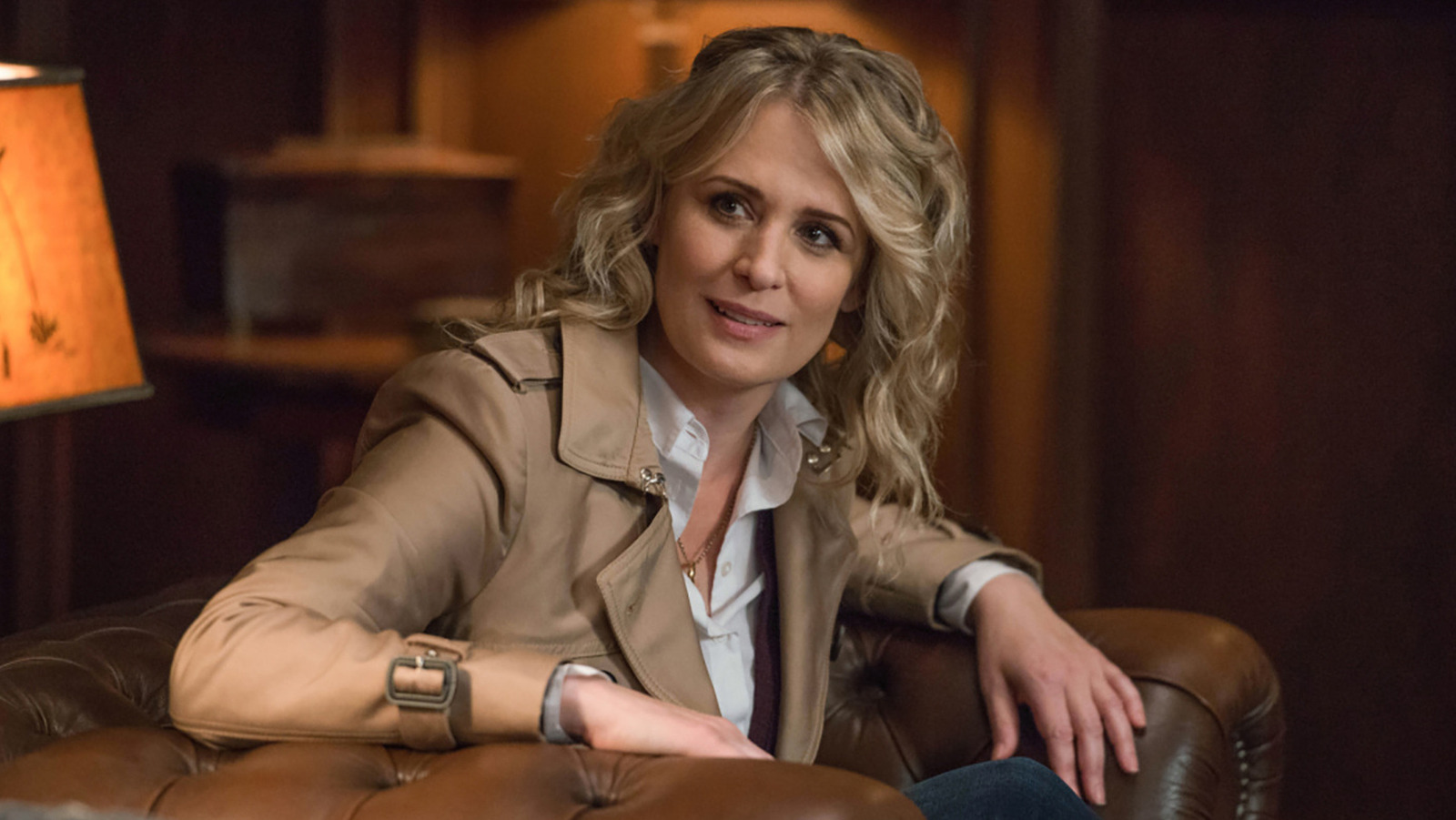 Mary Winchester, played by Samantha Smith, sits in a leather chair, looking at someone offscreen.