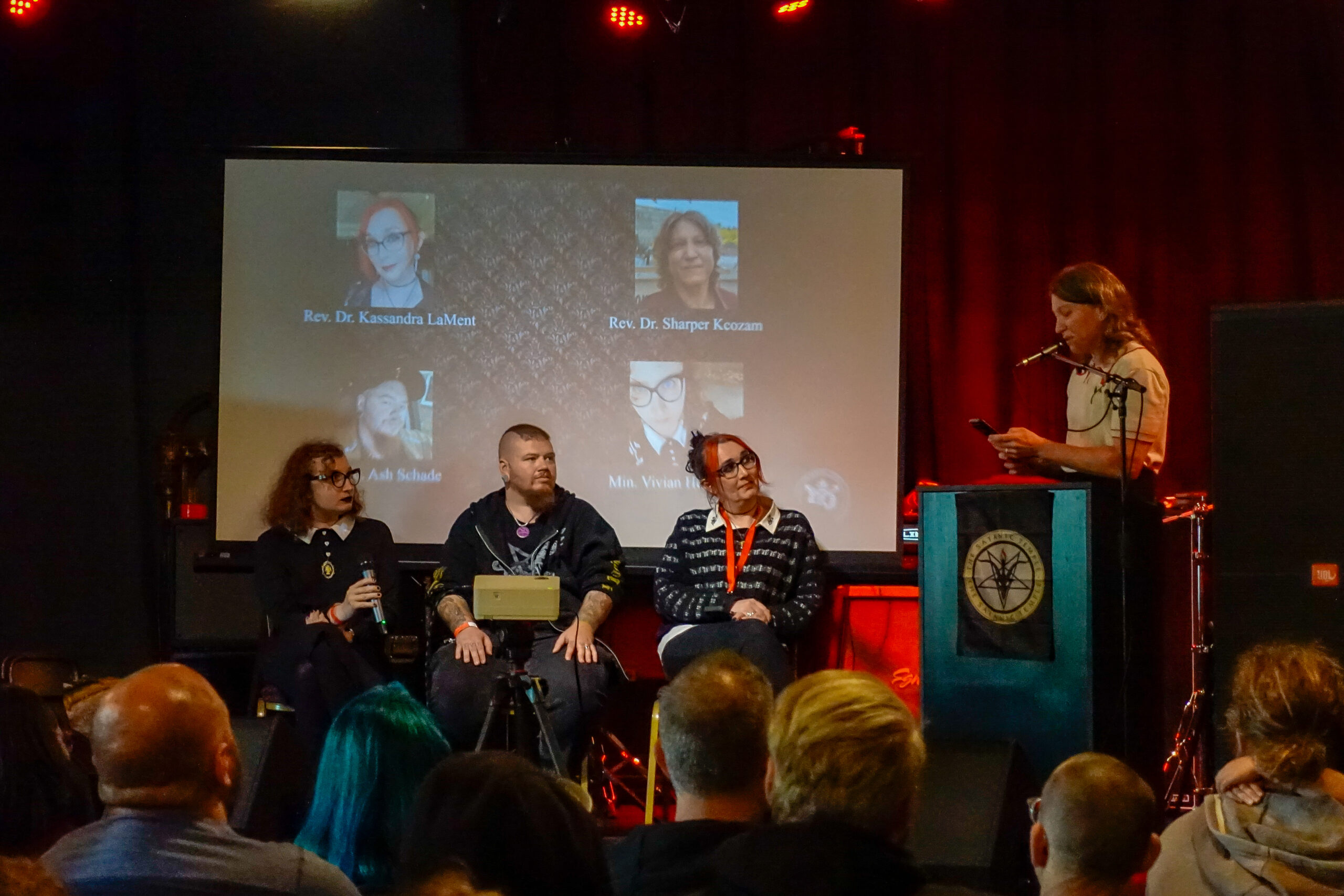 The panelists of the "Transatanic" panel sit in a row onstage at TST's Satanic Revival event in Baltimore, MD.